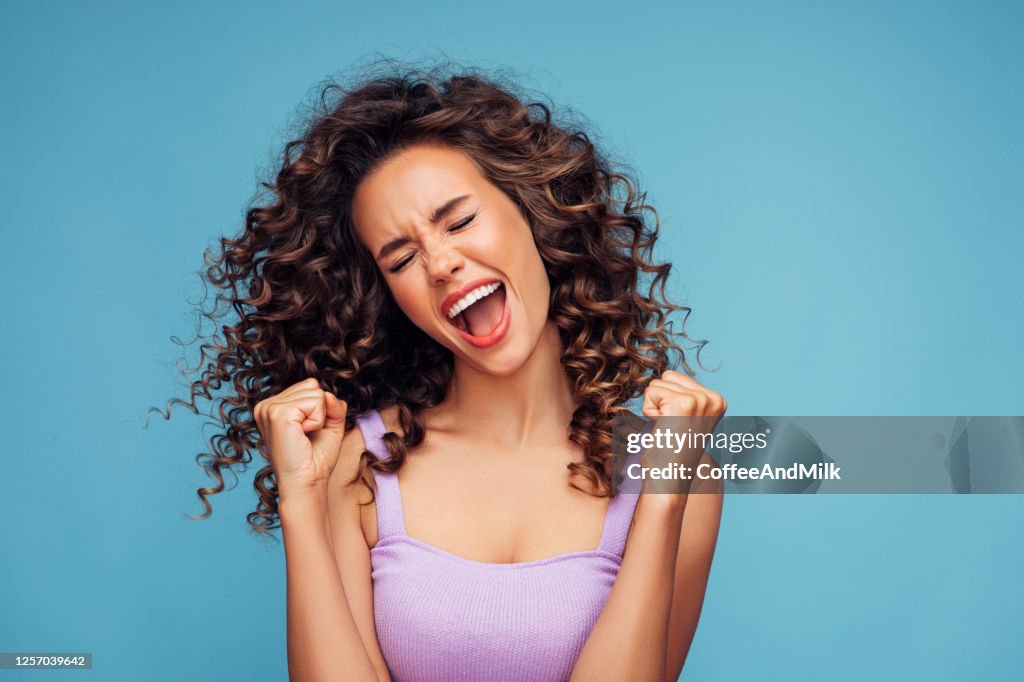 Girl on a blue background rejoices at her success