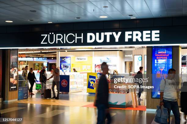 People walk past the Zurich airport Duty free shop.