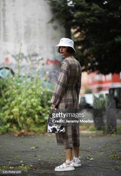 Lea Neumann wearing Prada bag, Weekday dress, Dr Martens sandals and Kangol bucket hat on July 15, 2020 in Berlin, Germany.