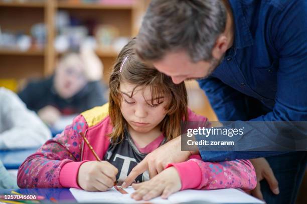 teacher working with a special need girl - special education stock pictures, royalty-free photos & images