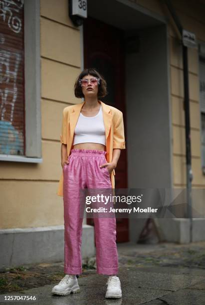 Lea Neumann wearing Komono shades, Stine Goya pants, vintage orange blazer, Urban Outfitters top and Eytys sneaker on July 15, 2020 in Berlin,...