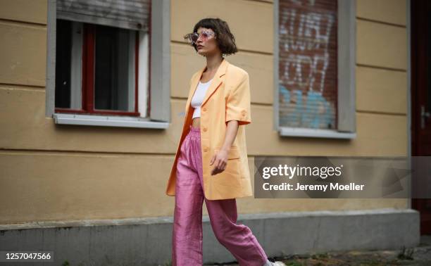 Lea Neumann wearing Komono shades, Stine Goya pants, vintage orange blazer, Urban Outfitters top and Eytys sneaker on July 15, 2020 in Berlin,...