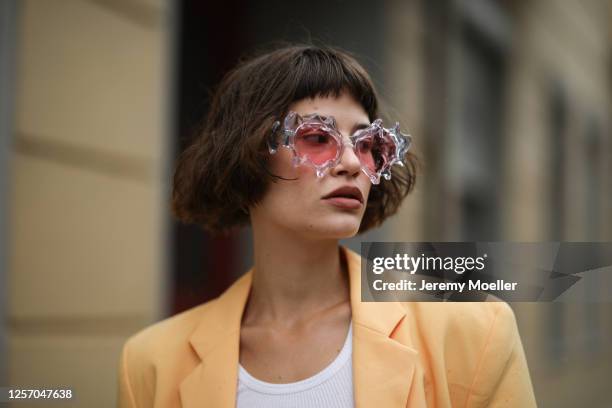 Lea Neumann wearing Komono shades, vintage orange blazer and Urban Outfitters top on July 15, 2020 in Berlin, Germany.