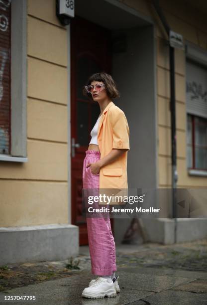 Lea Neumann wearing Komono shades, Stine Goya pants, vintage orange blazer, Urban Outfitters top and Eytys sneaker on July 15, 2020 in Berlin,...