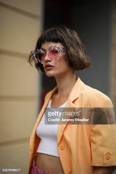 Lea Neumann wearing Komono shades, Stine Goya pants, vintage orange blazer, Urban Outfitters top on July 15, 2020 in Berlin, Germany.