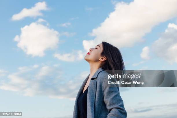 young lady embracing hope and freedom - espoir photos et images de collection