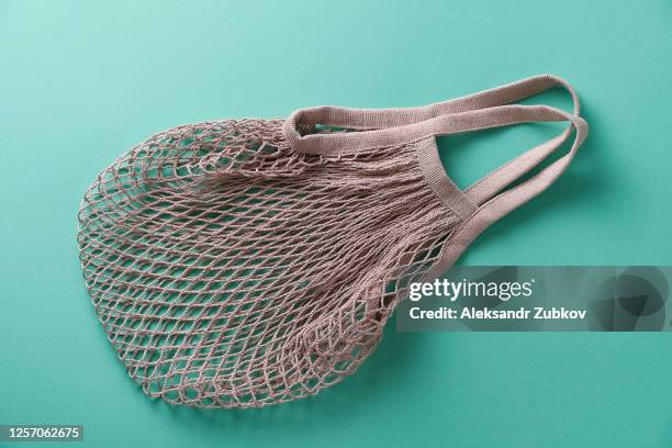 reusable shopping bag, string bag made of recycled materials, isolated on a green pastel background. - insulated bag stock pictures, royalty-free photos & images