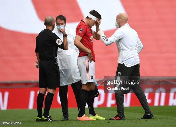 Harry Maguire of Manchester United is seen to by medical staff as they put a bandage around his head after a head injury during the FA Cup Semi Final...