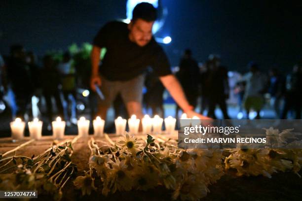 Alianza's supporters pay their respects to the victims of a stampede at a makeshift memorial outside Cuscatlan stadium in San Salvador on May 21,...