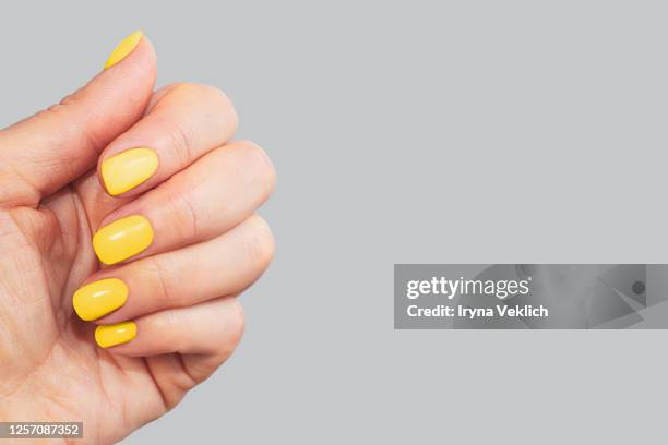 stylish neon yellow manicure on gray background. - nagellack bildbanksfoton och bilder