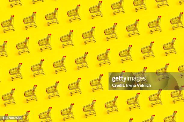 shopping trolley pattern on yellow background. - black friday shoppers stockfoto's en -beelden