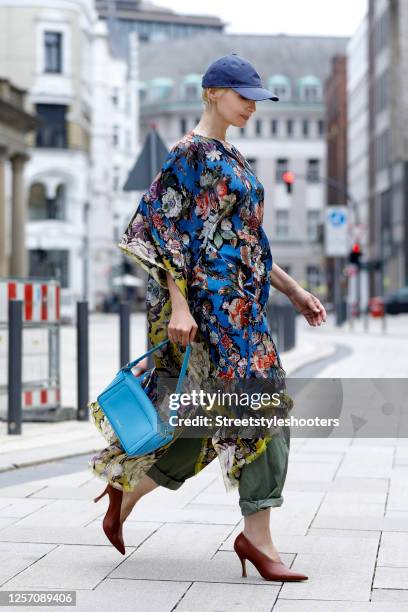 German presenter Susann Atwell wearing a light blue bag by Stiebich & Rieth, brown pumps by Dries van Noten, olive green pants by Odeeh, a blue cap...