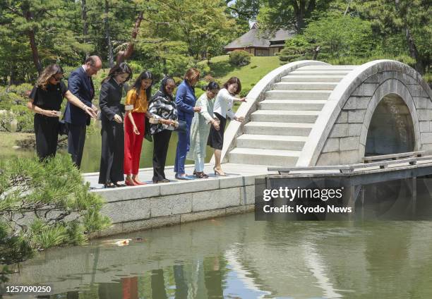 Spouses of Group of Seven leaders, including Yuko Kishida of Japan, Kim Keon Hee of South Korea and Akshata Murty of Britain, feed koi carp at...