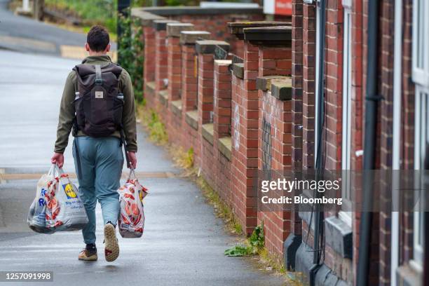 Customer carries grocery shopping bags in Sheffield, UK, on Friday, May 19, 2023. The Office for National Statistics are due to release the latest UK...