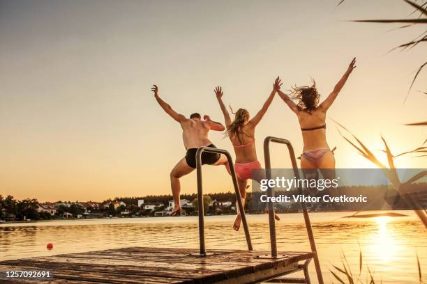they have never felt more free! - jumping into lake stock pictures, royalty-free photos & images