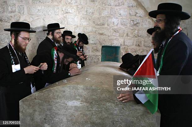 Members of Neturei Karta, a small faction of ultra-Orthodox Jews who oppose Israel's existence, hold Palestinian flags as they visit Joseph's Tomb, a...