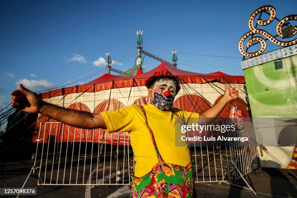 Performer from Circus Estoril wearing a face mask welcomes spectators before a night of drive-in performance amidst the coronavirus pandemic on July...