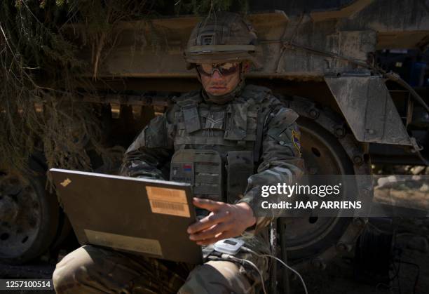 Member of the US armed fores is seen with a laptop during the NATO Spring Storm exercises in Sakussaare, Estonia on May 20, 2023. The Spring Storm...