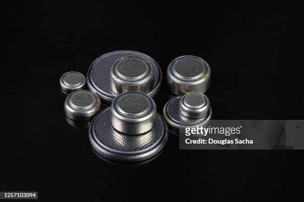 assortment of coin batteries on a black background - mercury metal stock pictures, royalty-free photos & images