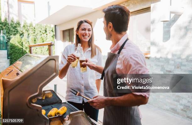 junges paar, das in seinem garten grillt. - couple grilling stock-fotos und bilder