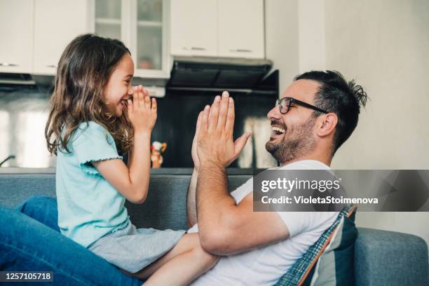 young father playing with his cute little daughter - clapping game stock pictures, royalty-free photos & images