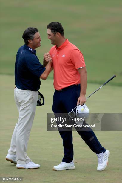 Jon Rahm of Spain is congratulated by Ryan Palmer of the United States after winning on the 18th green during the final round of The Memorial...