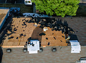 Working roofers on replacing the roof of residential building