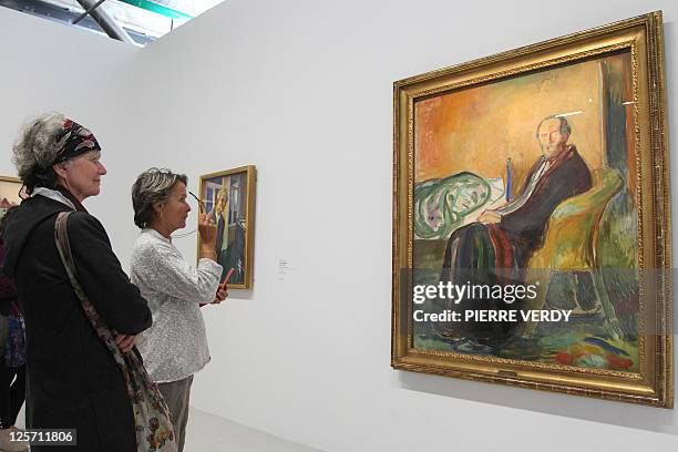 Visitors look at the painting "Autoportrait avec la grippe espagnole" at the Centre Pompidou modern art museum, also known as the 'Centre Beaubourg',...