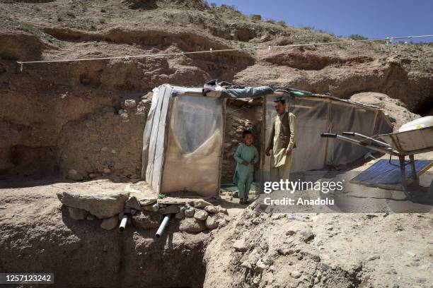 An Afghan family living in a cave is seen in front of a cave, while many people struggle with drought, hunger, disease and malnutrition in Bamyan...