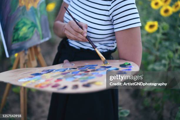 young woman painting sunflowers outdoors - paintbrush palette stock pictures, royalty-free photos & images