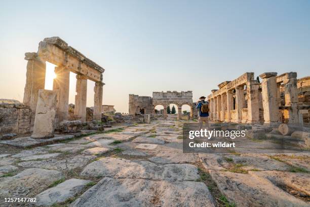 traveller tourist is taking photo of frontinus gate in ancient ruins in hierapolis , pamukkale - greek roman civilization stock pictures, royalty-free photos & images