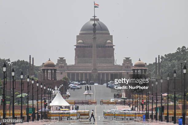 Man walks through a mirage on a hot summer day on Kartavya Path, formerly known as Rajpath, in front of India's Presidental Palace, in New Delhi,...