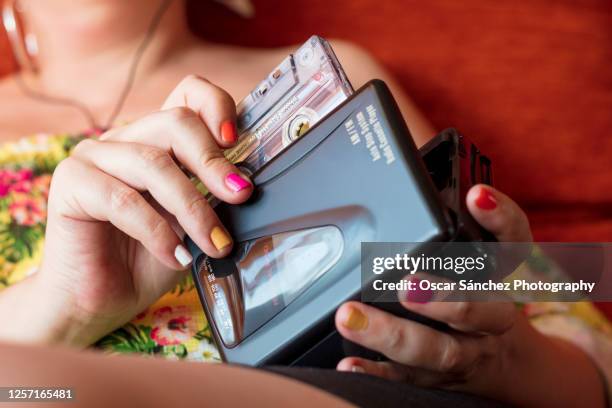 close-up of a woman inserting a cassette tape into a 80s personal player - inserts stock pictures, royalty-free photos & images