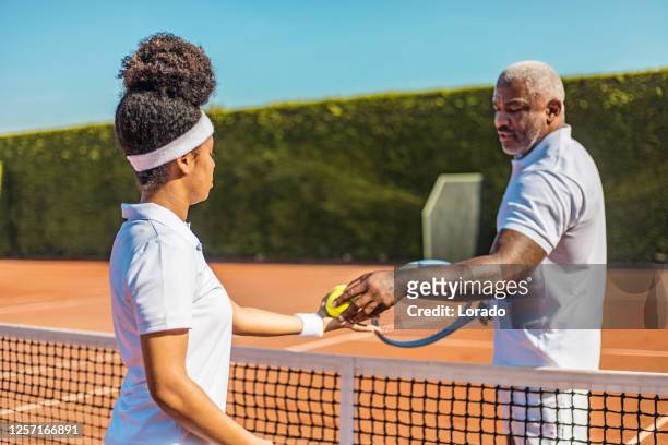 a beautiful black female tennis player on the court with her coach father - country club woman stock pictures, royalty-free photos & images