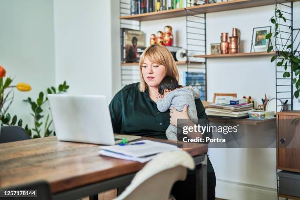 mutter mit neugeborenem arbeitet zu hause - multitasking stock-fotos und bilder