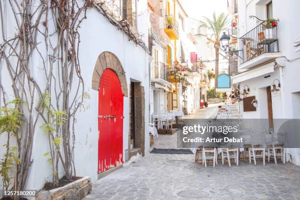 white street of the old town of ibiza with restaurants and architecture. calle blanca del pueblo de ibiza con encanto y arquitectura. - ibiza island stock pictures, royalty-free photos & images