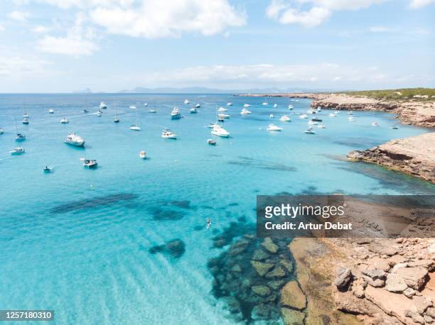 aerial view of the formentera island with paradise beach and yachts in the mediterranean sea with the ibiza island silhouette. toma aérea de la isla de formentera con playas paradisiacas y yates. - vista aérea stock pictures, royalty-free photos & images