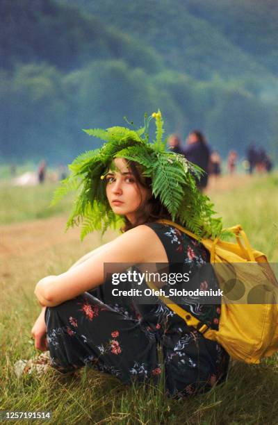 frau mit farnkranz sitzt auf wiese in den bergen - fashion archive mellow yellow stock-fotos und bilder