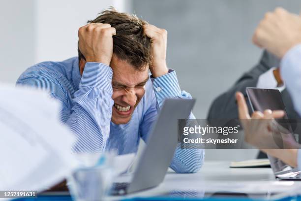 angry mid adult businessman feeling displeased in the office. - pulling hair stock pictures, royalty-free photos & images