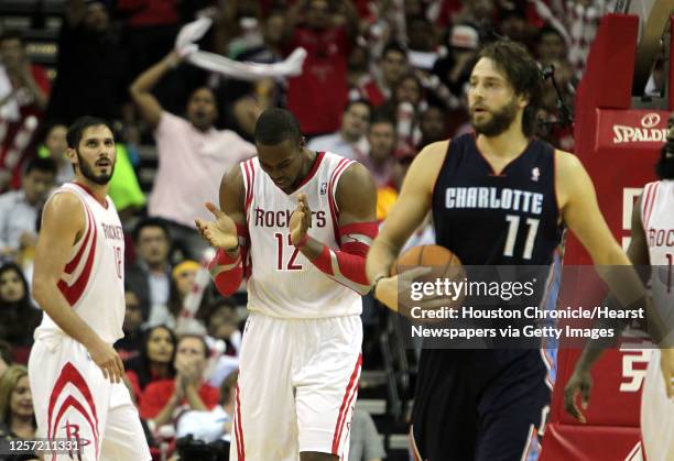 Houston Rockets small forward Omri Casspi left, looks on as teammate Houston Rockets center Dwight Howard center claps and Charlotte Bobcats power...