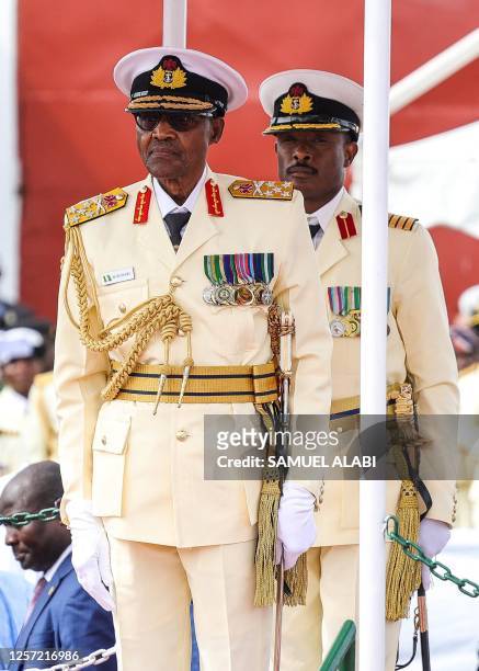 Outgoing nigerian President Muhammadu Buhari stands during the military parade held at the presidential fleet review held at the Naval Dockyard in...
