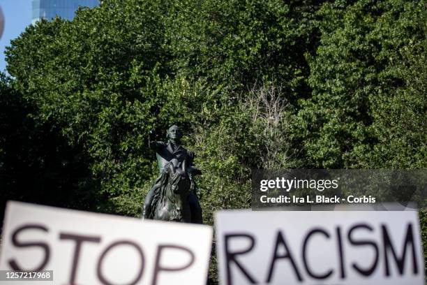 July 18: A protester holds signs that say, "Stop Racism" are held in front of the George Washington Statue in Union Square, New York. This was the...