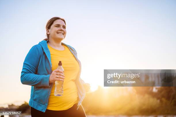 young overweight woman running - fat stock pictures, royalty-free photos & images