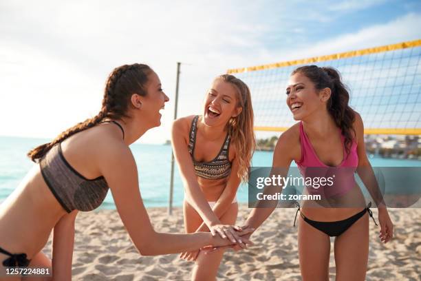 group of friends holding their hands stacked - beach volleyball friends stock pictures, royalty-free photos & images