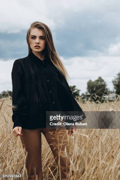 portrait of beautiful young stylish woman in black shirt - beige pants stock-fotos und bilder