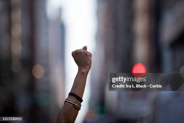 July 18: A protester holds a raised black power fist in between the buildings as they marched from Union Square to City Hall in Manhattan. This was...