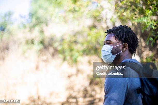 young black man wearing a face mask while hiking - black people wearing masks stock pictures, royalty-free photos & images