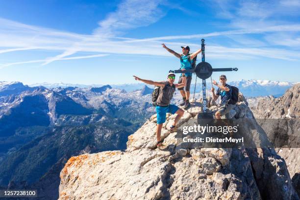 tree climber on the summit cross on top of watzmann - team climbing up to mountain top stock pictures, royalty-free photos & images