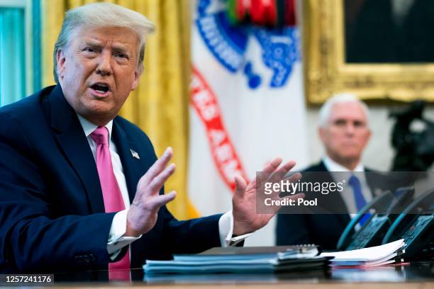 President Donald Trump talks to reporters with Vice President Mike Pence in the Oval Office at the White House July 20, 2020 in Washington, DC. Trump...
