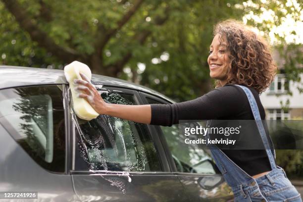 junge frau waschen auto auf einfahrt - car in driveway stock-fotos und bilder